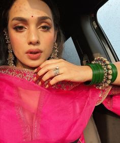 a woman in a pink sari is sitting in the back seat of a car