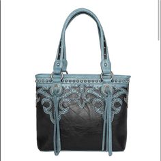 Tote Has: Cut-Out Boot Scroll With Contrasting Stitching Antique Silver Embellishments Antique Silver Concho With Tassels Top Zipper Closure Inside Single Compartment Divided By A Medium Zippered Pocket Inside Of Bag Include A Zippered Pocket And 2 Open Pockets A Zippered Pocket On The Back To Conceal The Handgun (9.5"X 5") An Open Pocket On The Back Metal Feet On The Bottom For Protection And Stability Double Studded Detail Flat Strap 14.5" X 4.75" X 10.5"Drop 10.5" Western Trend, Contrasting Stitching, Western Purses, Tassel Top, Contrast Stitch, Western Wear, Womens Tote Bags, Inside Pocket, Montana