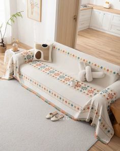 a living room with a white couch covered in blankets