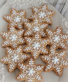 some cookies that are on a plate with snowflakes in the middle and white frosting