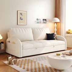 a living room with a white couch and coffee table next to a large painting on the wall