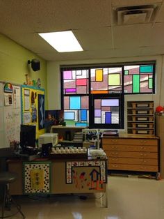 a classroom with lots of windows and desks in front of the teacher's desk