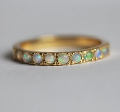 Australian opal wedding band. Elegant and simple half eternity ring with opal cabochons.
If you would prefer a full eternity ring, please contact us before purchase.
Details
Gemstones: round Australian opal cabochons
Measurements: approx. 2mm (9)
Setting: pave/prong
Band measurements: approx. 2.7mm wide
Material: 14k/18k solid yellow, white, rose gold or platinum for an additional fee
Sizes available: 2-8 (Larger and smaller sizes are available as well. Priced upon request.)
The design can be ma Wedding Ring With Opal, Opal Ring Simple, Puppy Wedding, Fire Opal Engagement Ring, Simple Wedding Ring, Opal Wedding Band, Emerald Wedding Rings, Opal Band, Opal Wedding Rings