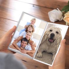 a person holding an open photo book with pictures of people and a dog