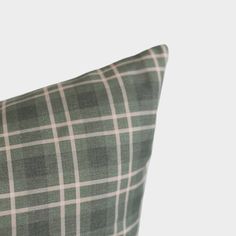 a green and white checkered pillow sitting on top of a table