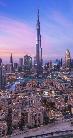 an aerial view of the city at dusk, with skyscrapers and other buildings in the background