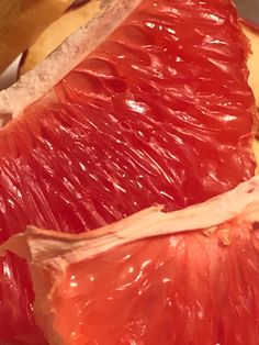 two pieces of grapefruit sitting on top of a table next to banana peels