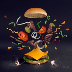 a hamburger flying through the air with confetti falling out of it