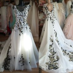 two dresses on mannequins, one with black and white floral appliques