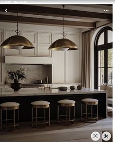 an image of a kitchen setting with bar stools and pendant lights over the island