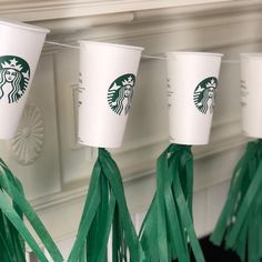 starbucks cups are lined up with tassels