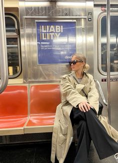 a woman sitting on a subway train with her legs crossed