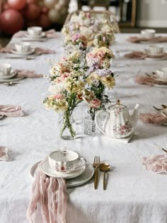 the table is set with pink and white flowers