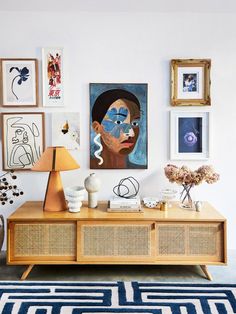 a living room with pictures on the wall and a wooden table in front of it