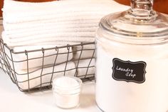 a large glass jar sitting on top of a table next to towels and a basket