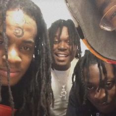 four young men with dreadlocks are posing for a photo in front of a mirror