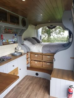 an instagram photo of the inside of a camper with wood flooring and white cabinets