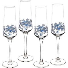 four wine glasses sitting next to each other on top of a white surface with blue flowers