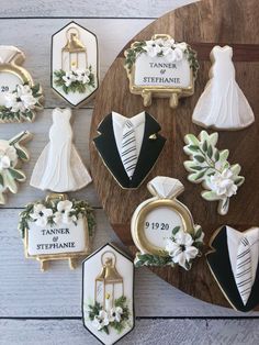 decorated wedding cookies on a wooden platter with name tags and names for the bride and groom