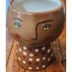 a ceramic cup with a face painted on it