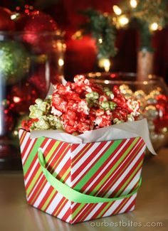 a candy cane box filled with popcorn on top of a table next to christmas decorations