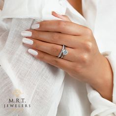 a woman's hand wearing a diamond ring and white shirt with her hands on her chest