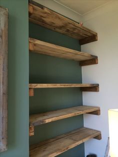 some wooden shelves in a room with green walls