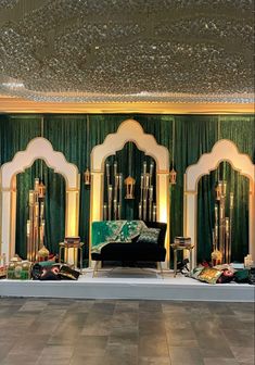 an elaborately decorated stage set up with green curtains and gold accents on the walls