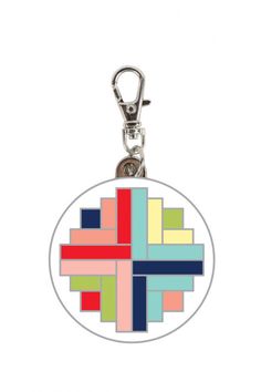 a round keychain with an abstract design on the front and back side of it