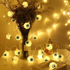 a vase filled with lots of white lights next to a bunch of fake eyeballs