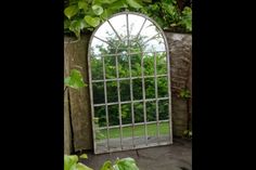 an arched window is surrounded by greenery