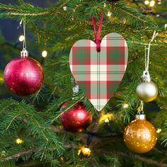 a christmas tree with ornaments hanging from it's branches in the shape of a heart