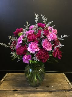 a vase filled with purple flowers on top of a wooden table