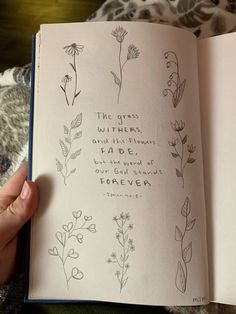 a person is holding an open book with flowers on it and the words written in cursive writing