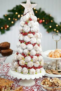 a christmas tree made out of cookies and pastries on a table with other desserts