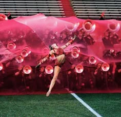 a woman is dancing in front of a giant red sheet with bubbles on the side