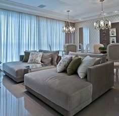 a living room filled with lots of furniture next to a dining room table and chairs