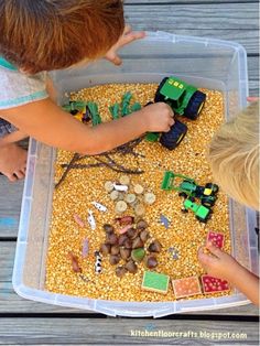 two children playing with toys in a plastic container