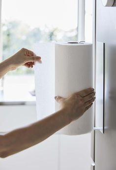 a person holding a roll of toilet paper