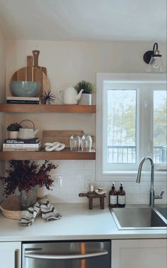 the kitchen is clean and ready for us to use it's shelves are filled with dishes