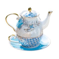 a blue and white teapot with gold trimmings on the top, sitting on a saucer