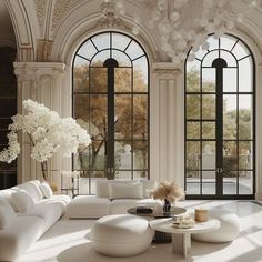 an elegant living room with white furniture and large windows