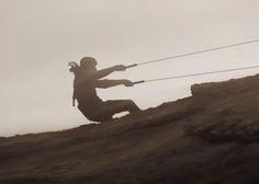 a man holding two ropes on top of a hill