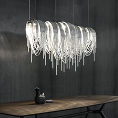 a modern chandelier hanging over a wooden table