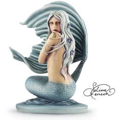 a statue of a mermaid sitting on top of a rock