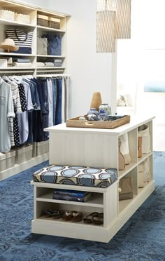 an organized closet with blue carpeting and white shelves filled with shirts, shoes and other items