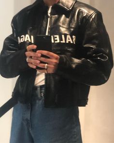 a man wearing a black leather jacket with the word balef iag on it