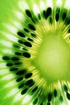 the inside of a kiwi fruit with black dots on it's green center