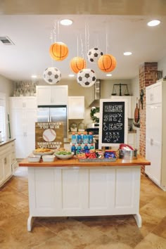 a kitchen with lots of food on the counter and hanging lights above it that says happy birthday