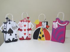 four different colored paper bags with playing cards on the front and sides, all decorated in various shapes and sizes